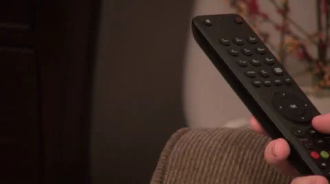Watching TV, changing channels, remote control, channel surfing, closeup Stock Footage 33795789