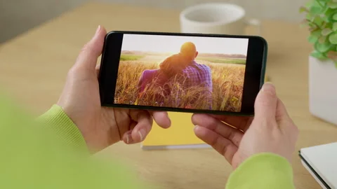 Watching a video on your phone while holding it in your hands.  Stock Footage 286706528