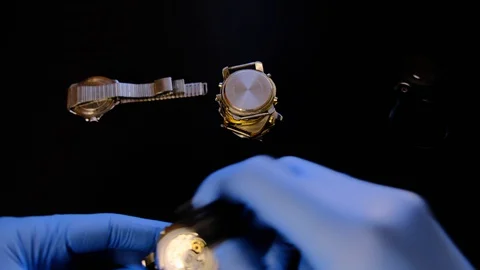 Watchmaker build a tower of old mechanical watches in his workshop. Man inspects Stock Footage 129999306