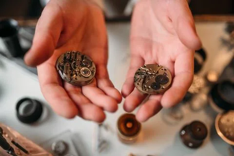 Watchmaker hands with clockwork mechanism closeup Stock Photos