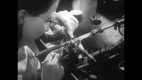 A watchmaker makes balance staffs at the Hamilton Watch Factory in the 1940s. Vídeos de archivo 88554180