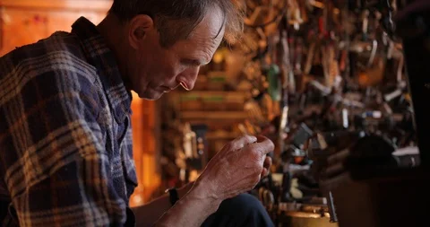 A watchmaker in a shirt sits in a workshop and repairs an old watch. vintage Vídeos de archivo 127944123
