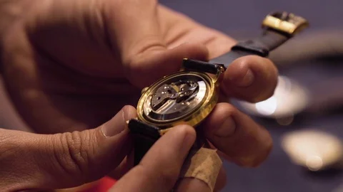 Watchmaker shows off the inside of a watch as it ticks away Stock Footage 114433414