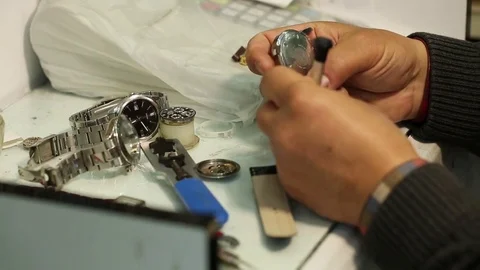 Watchmaker is working on removing the battery of quartz watches and analyzing th Stock-Footage 75451078