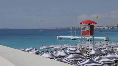 Watchtower for rescue at sea and blue parasols on French riviera beach Stock Footage