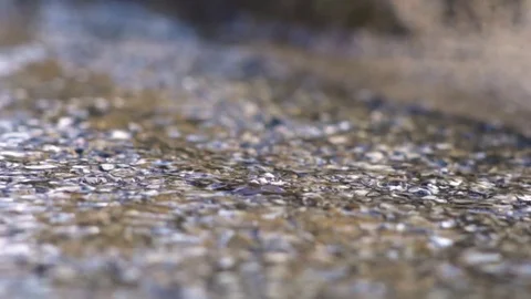 Water after rain running down pebbles Stock Footage 124938329