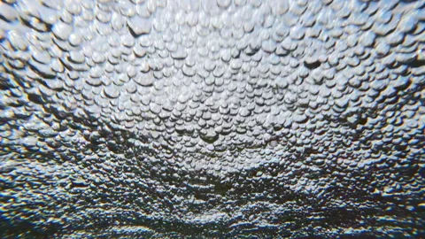 Water air bubbles across surface of water in rapid stream quickly rushing Stock Footage 333514775