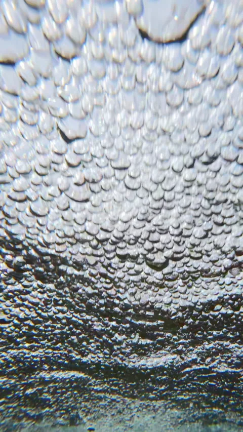 Water air bubbles across surface of water in rapid stream quickly rushing Stock Footage 345864389