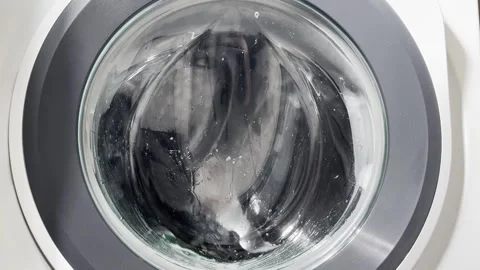 Water and detergent move inside the spinning drum during an active wash cyc.. Stock Footage 323120002