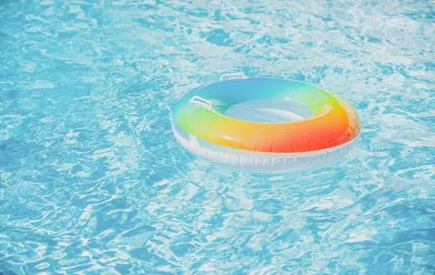 Water background. Pool float, ring floating in a refreshing blue swimming pool Stock Photos