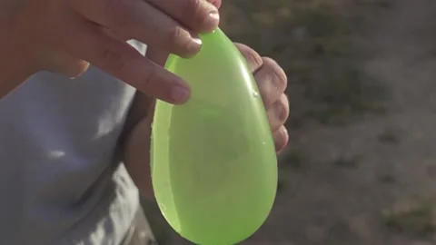 Water balloon exploding in one hand in super slow motion Video stock 135930341