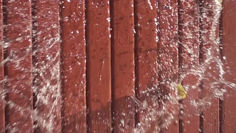 Water balloon exploding on wooden boards. Water explosion in slow motion Video stock 146810785