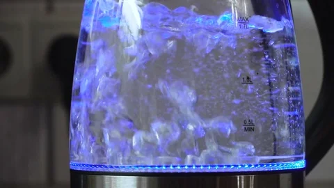 Water boiling with bubbles in transparent electric kettle with blue illumination Stock Footage 84277738