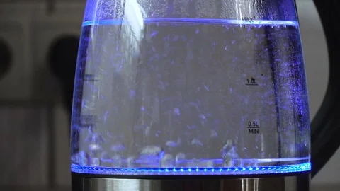 Water boiling with bubbles in transparent electric kettle with blue illumination Stock Footage 84277741