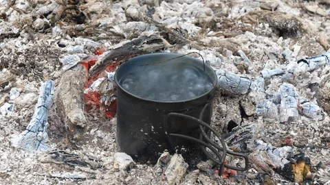 Water Boiling in Cup over Campfire in Woods Stock Footage 112683609