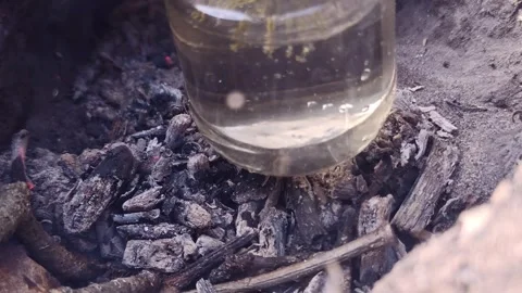 Water boiling in a glass jar at a forest campfire Stock Footage 333844783