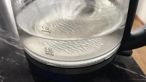 Water boiling in glass kettle close-up with cloudy mineral scale Stock Footage 345361574