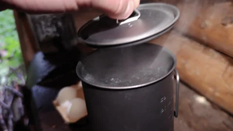Water Boiling Rapidly in Titanium Mug During Outdoor Camp Cooking 库存影片 347459863