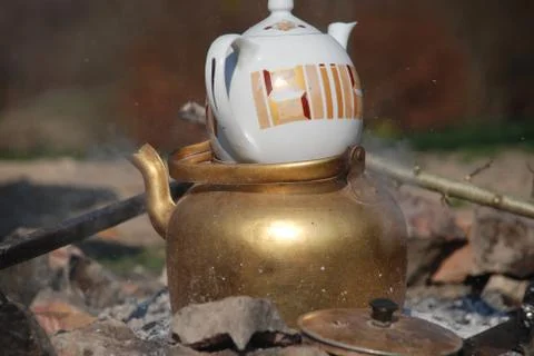 Water boiling in traditional kettle over charcoal fire Stock Photos