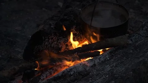 Water boils in a black pot on a fire. Stock Footage 130445231