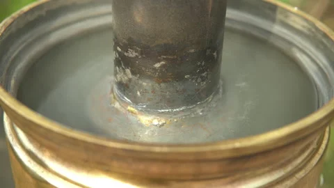 Water boils inside a brass samovar Cooking boiling water in a samovar Video stock 153935879