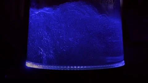 Water boils in a kettle with backlight. Close-up Stock Footage 230921427