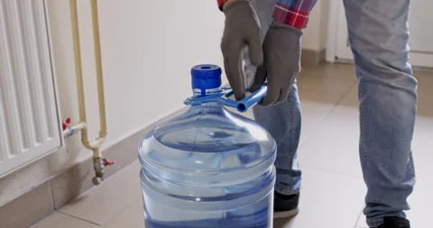 Water bottle cap falls off as courier lifts container Vídeos de archivo 294598931