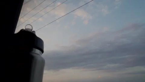 Water Bottle Frames a Calm, Cloud-Filled View from a Moving Journey Stock Footage 318477071