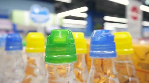 Water bottles with multi-colored plastic caps in a row. Stock Footage 262561982