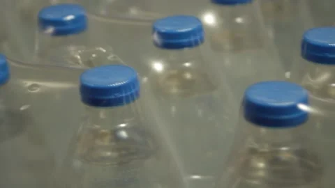 Water bottles. Plastic packages with blue lids in transparent pallets. Smooth Stock Footage 314978976