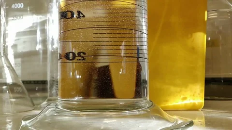 Water bubble formation in slow motion and reverse direction in a measuring cylin Stock Footage 104008028