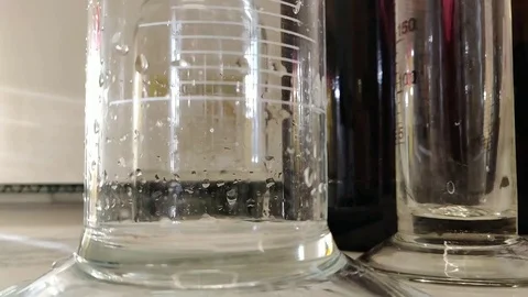 Water bubble formation in slow motion and forward direction in a measuring cy Stock Footage 104010511