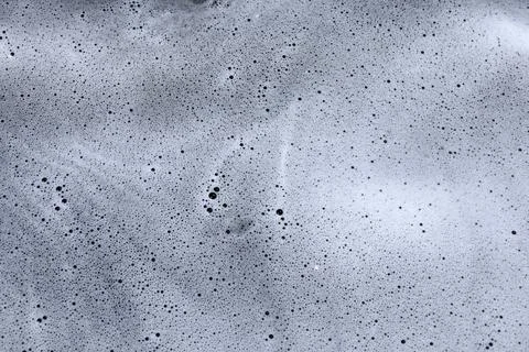 Water bubbles create patterns on a surface during a washing process in a Stock Photos