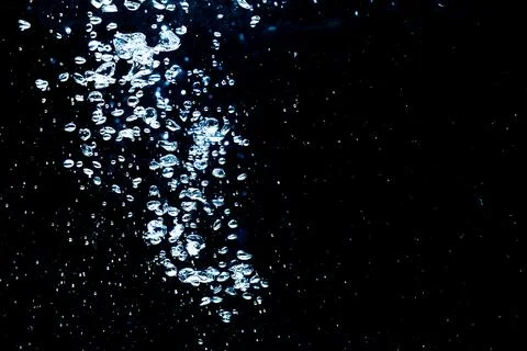 Water bubbles isolated on black background, close up view. Rippling liquid su Stock Photos