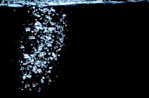 Water bubbles isolated on black background, close up view. Rippling liquid su Stock Photos