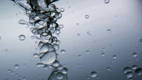 Water bubbles moving in a vortex in front of bright background in slowmotion Stock Footage 98946717