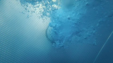 Water bubbles rising from pool drain on textured pool floor Stock Footage 342163327