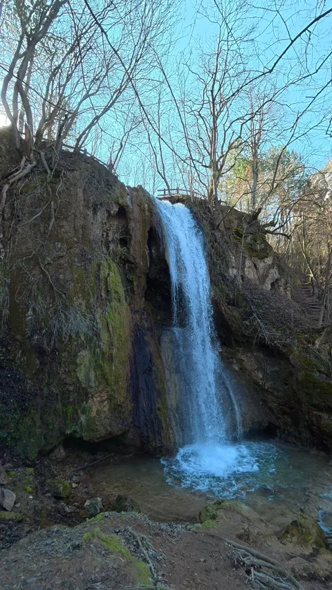 Water cascades down mossy rocks into a clear pool. Balkan, Eastern Europe, POV Vídeo Stock 333634233