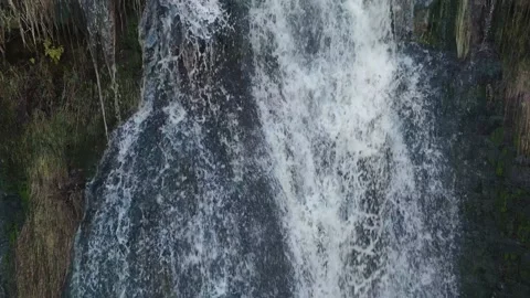 Water cascades down rocky cliffs, roaring with force 库存影片 342937225