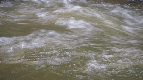Water cascades over smooth rocks in a mountain stream Stock Footage 281167422
