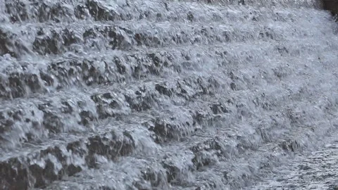 Water cascading down textured stone steps of a waterfall feature.  Stock Footage 342047811