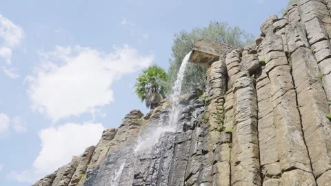 Water cascading down the unique volcanic rock formations of the basaltic prisms Video stock 342041884