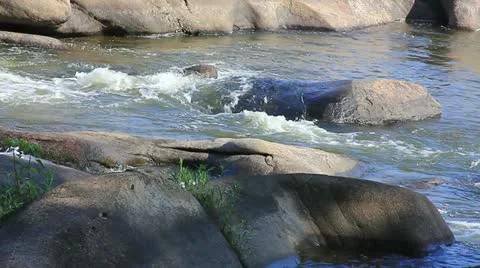 Water cascading over large river rocks Stock Footage 11058718