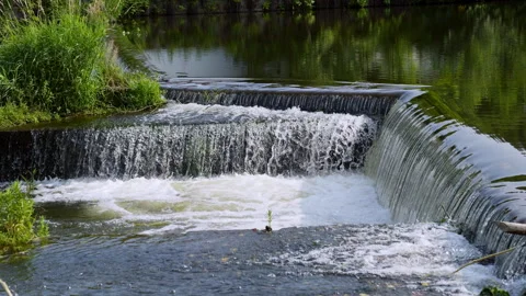 Water cascading over a small dam in slow motion Stock Footage 318196375