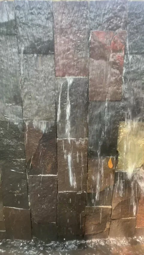 Water Cascading Over Textured Stone Wall Stock Footage 287994499