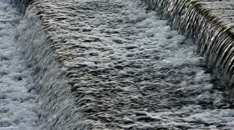 Water cascading over wier Stock Footage 9996401