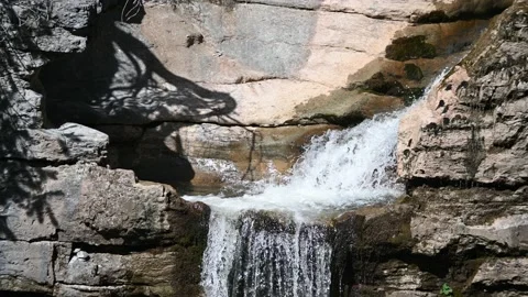 Water cascading into a small pool within beautiful rocks Stock Footage 219418563