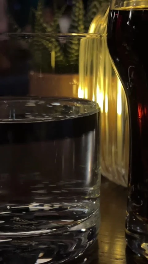 Water cola in a dark restaurant Big Glass Of Cola On A Terrace Table In A Stock Footage 293254102