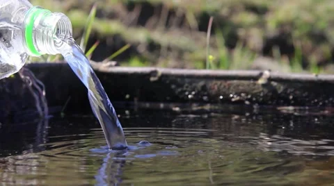 Water coming from the source through the pipe. An improvisation with a plastic  Stock Footage 59843215