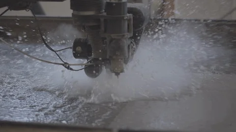A water-cut industry machine cuts a shape from a iron sheet. Close up shot Stock Footage 122084622